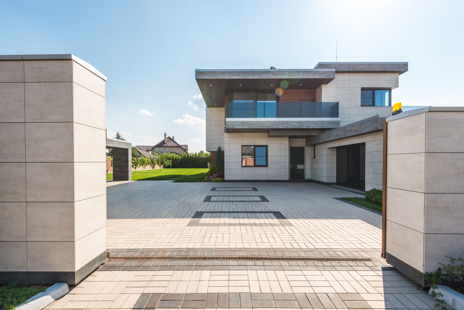 A completed block-paved driveway with drainage channel leading to a modern house